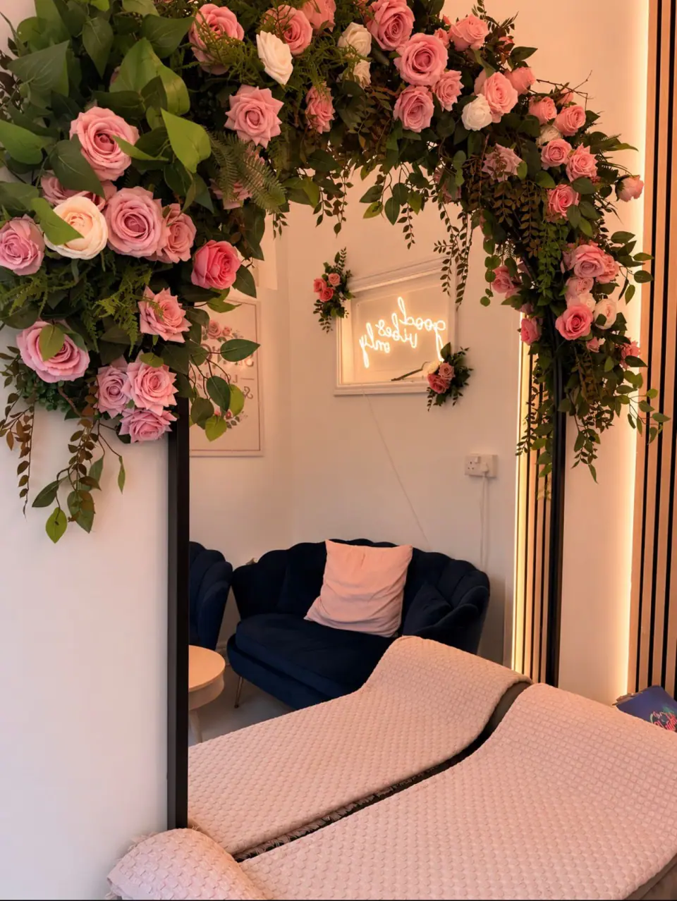 Pink roses frame a mirror reflecting Tina Rose's cosy lounge seating